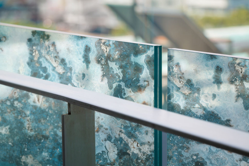 closeup modern flat stainless railing and glass wall on outdoor building.
